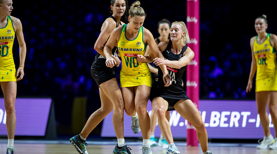 Jamie-Lee Price of the Australian Diamonds breaks through two New Zealand players and wins the ball in their match at the 2019 Netball World Cup in Liverpool.